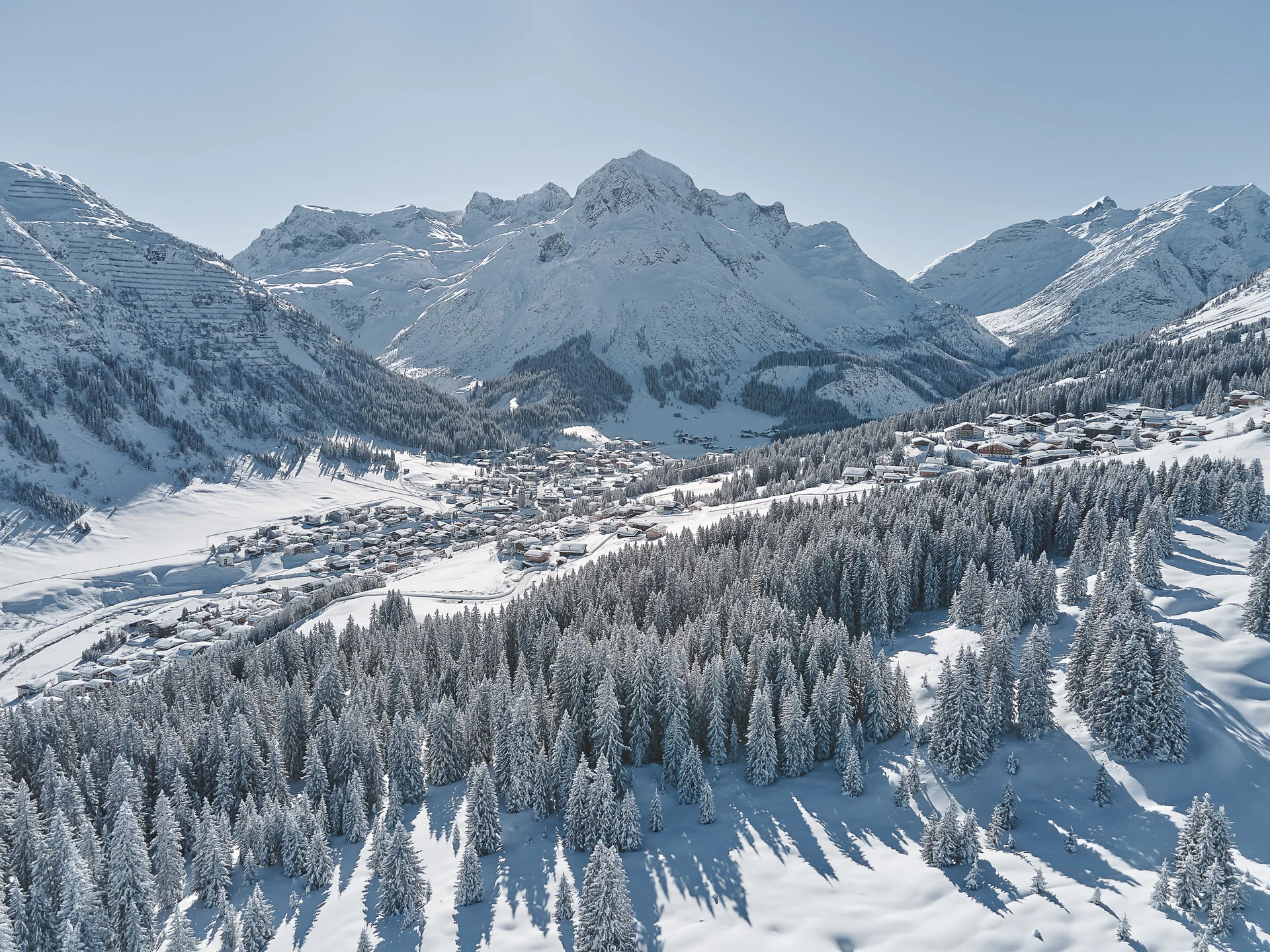 The journey to your hotel in Vorarlberg | Hotel Panorama Snow-covered alpine village among frosted fir trees and towering mountains