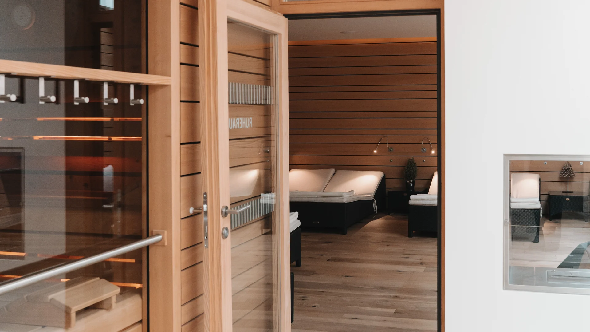 Picture gallery | Hotel Panorama in Lech am Arlberg View through a glass door into a wood-paneled sauna with loungers