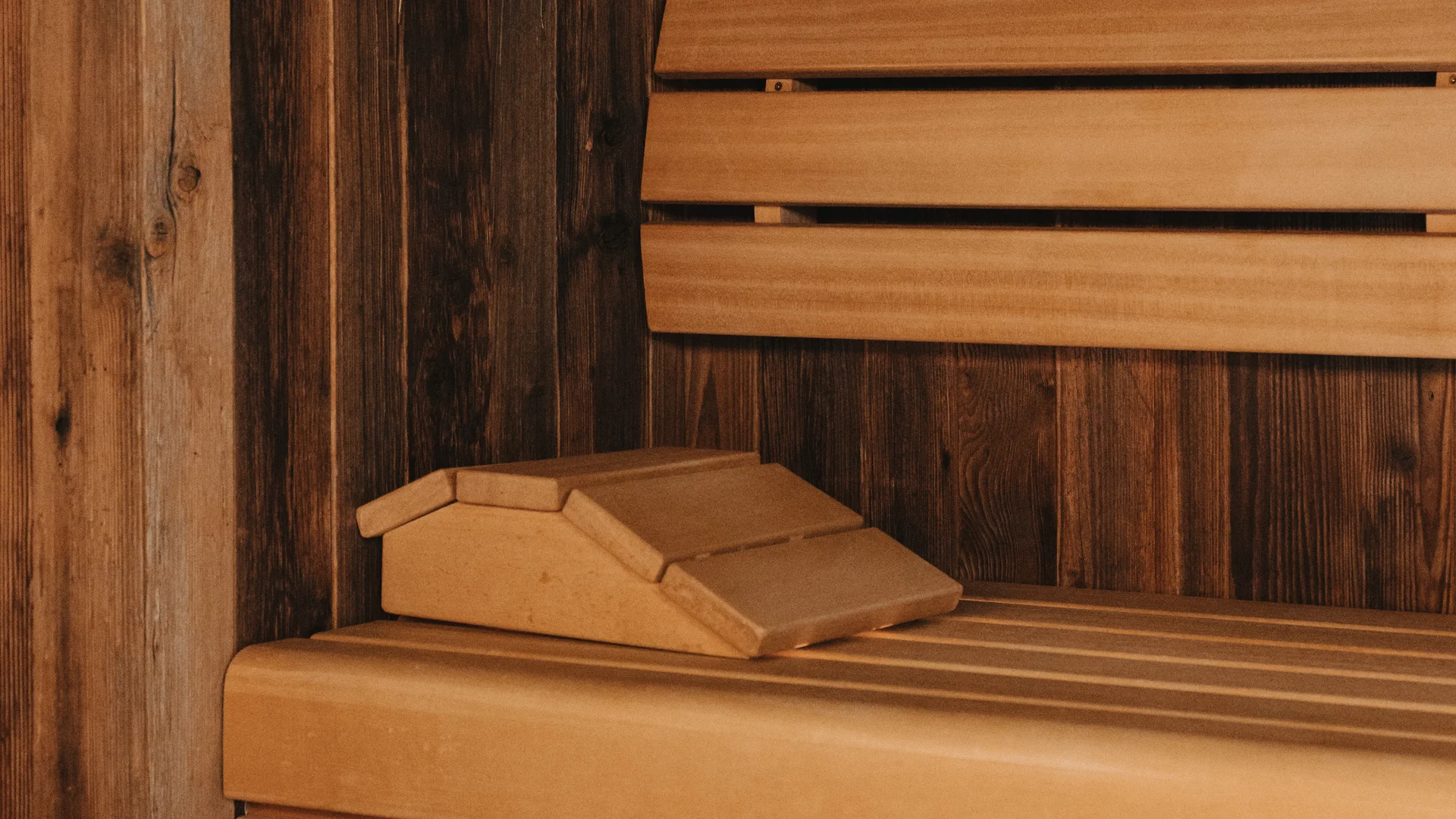 Wooden bench and paneling inside a warmly lit sauna