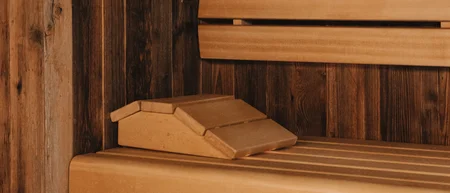 Wooden bench and paneling inside a warmly lit sauna