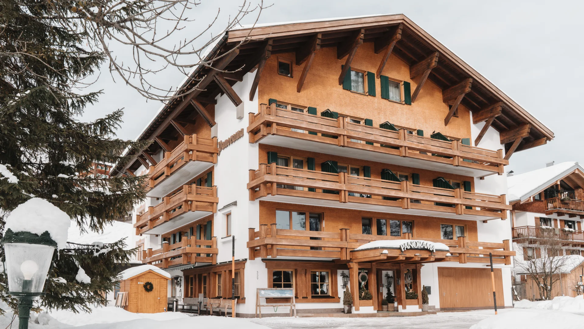 Picture gallery | Hotel Panorama in Lech am Arlberg Alpine-style building with wooden balconies and a snow-covered entrance