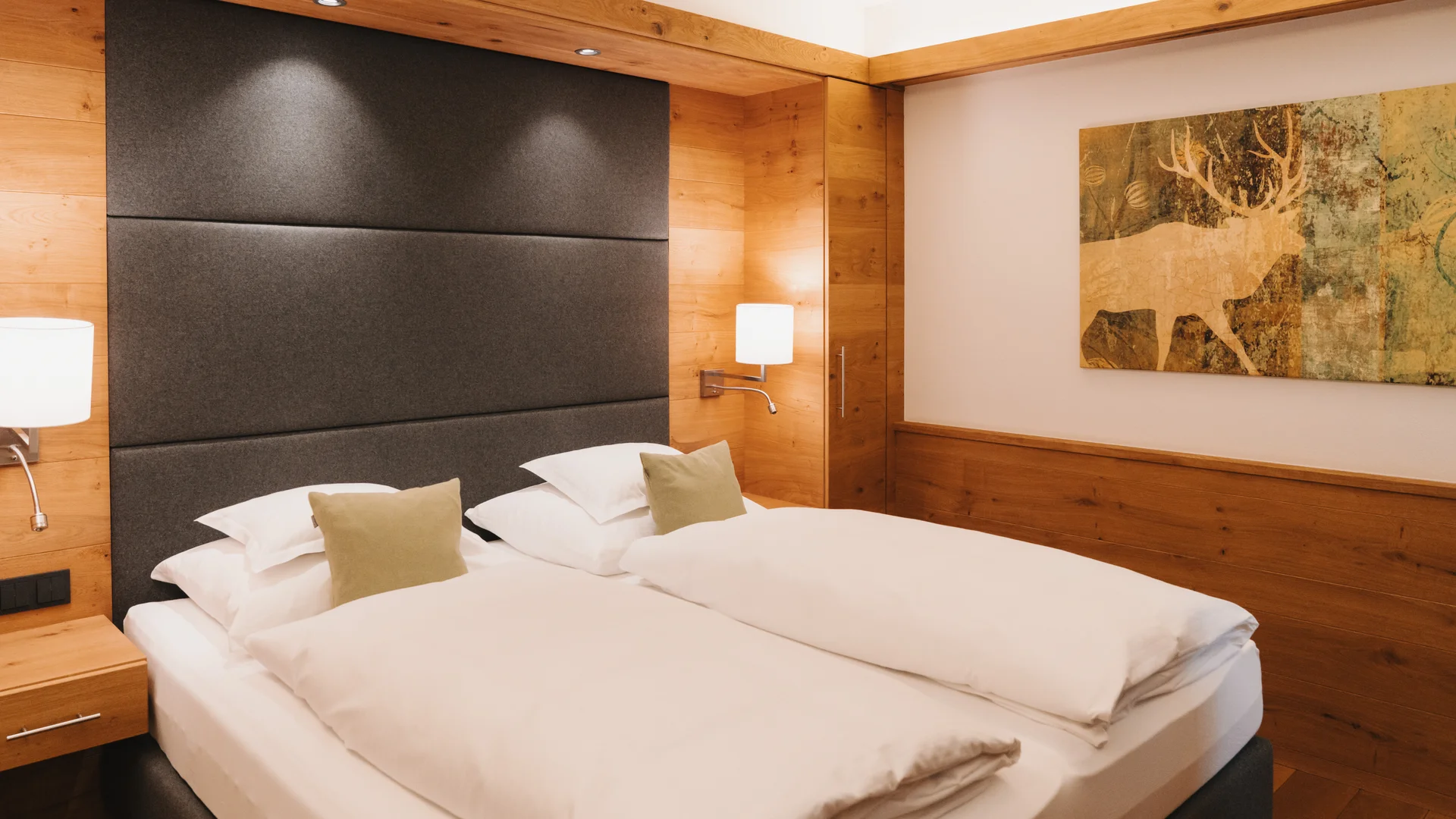 Picture gallery | Hotel Panorama in Lech am Arlberg Hotel room with two white beds, a dark headboard and warm wood paneling