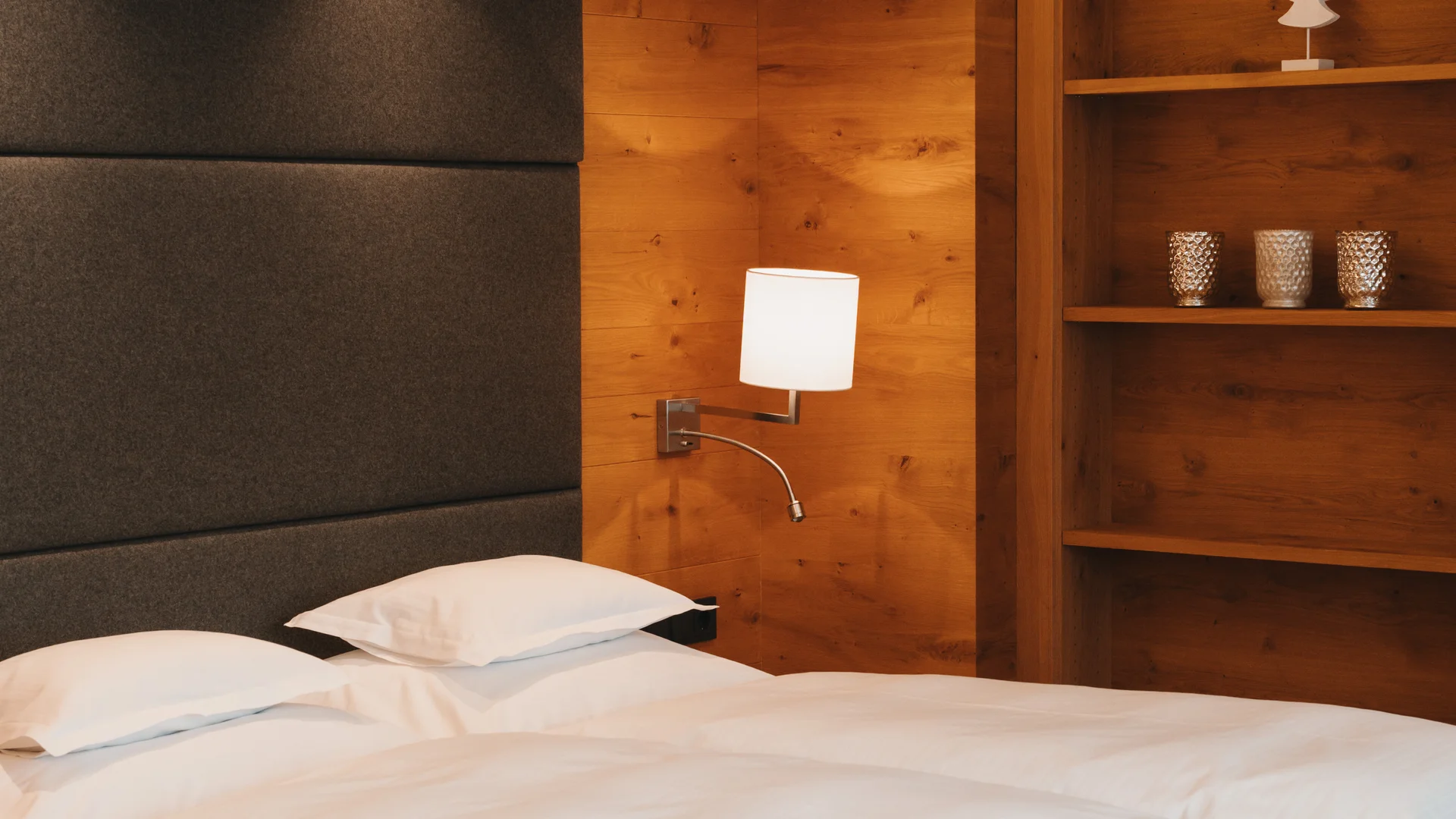 Picture gallery | Hotel Panorama in Lech am Arlberg Hotel room with a large bed, wood-paneled walls and open shelving