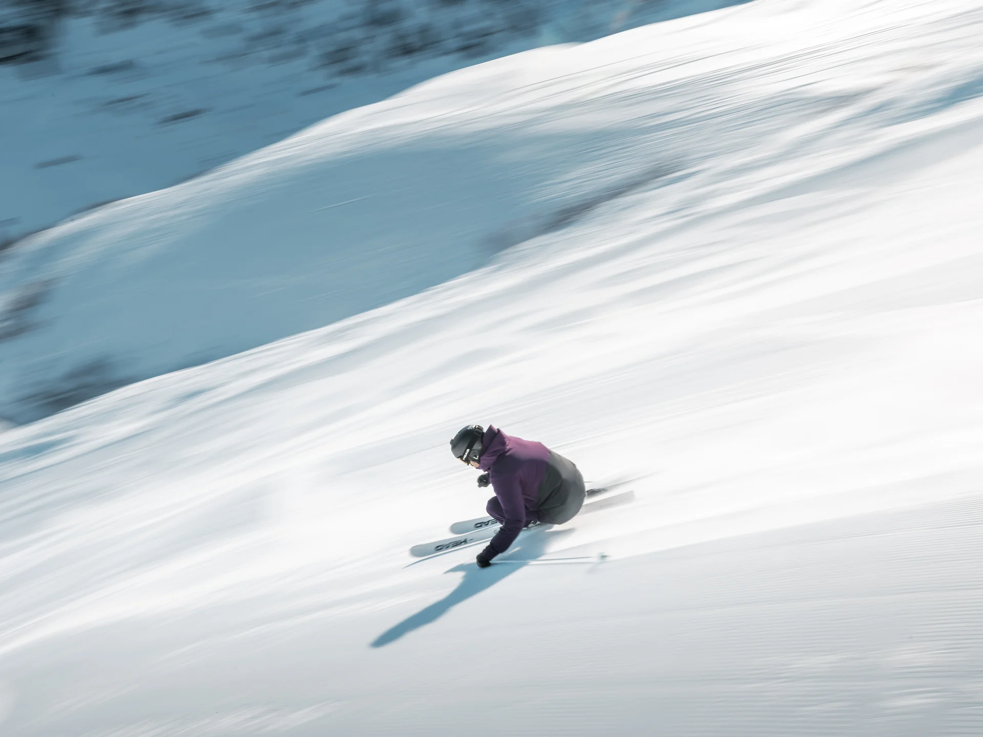 A ski holiday in Lech at Hotel Panorama Skier glides downhill in a crouch on a snowy slope