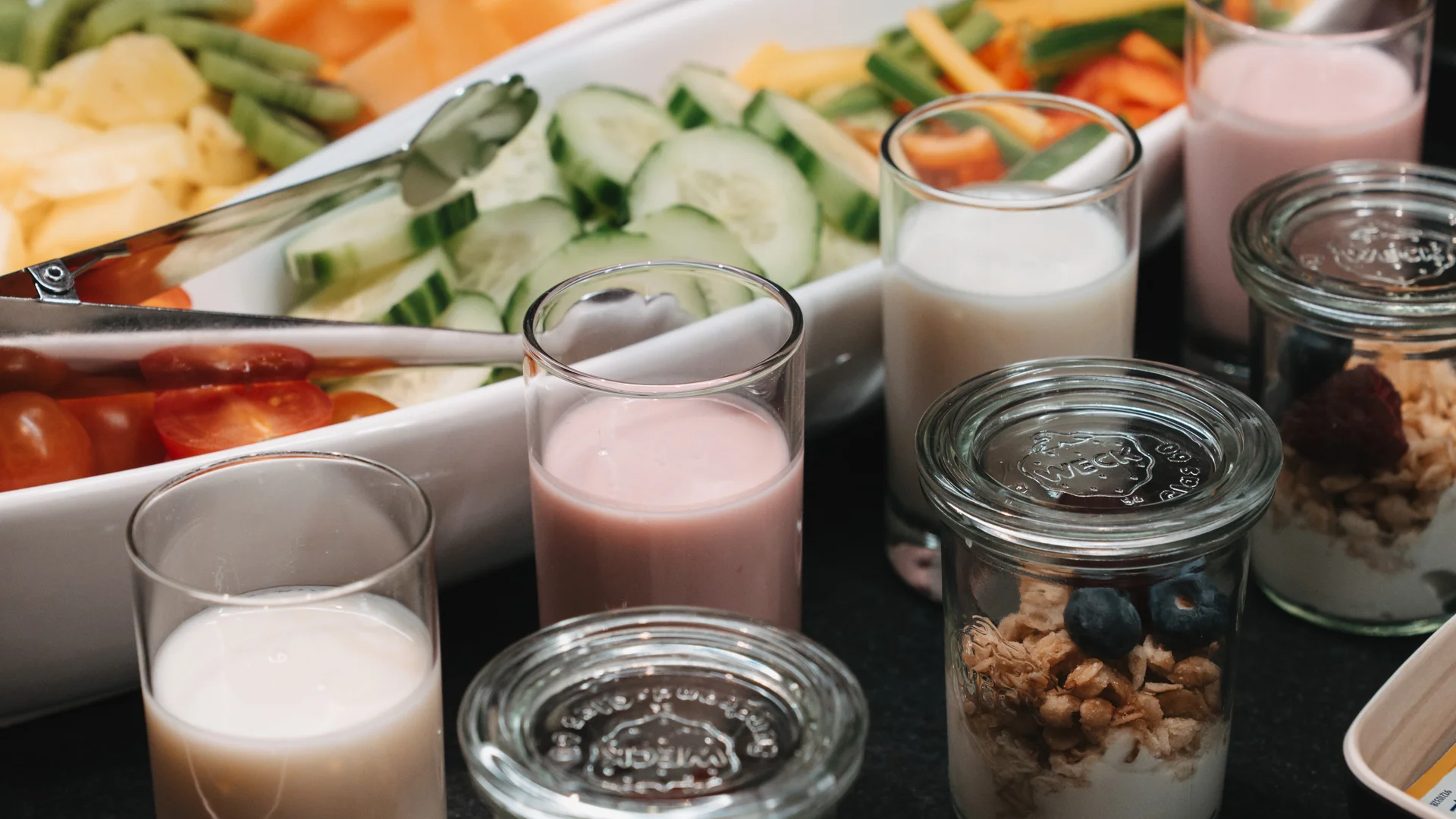 Picture gallery | Hotel Panorama in Lech am Arlberg Breakfast buffet with sliced vegetables, yogurt with granola, and glasses of milk
