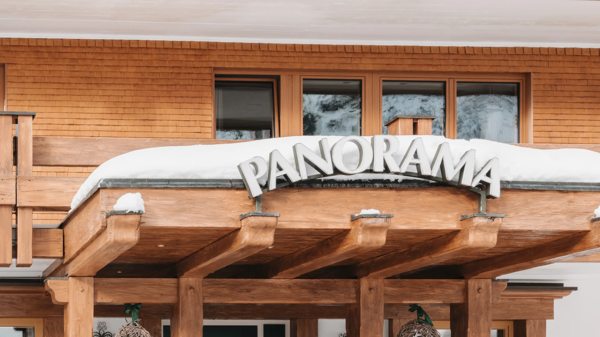 Picture gallery | Hotel Panorama in Lech am Arlberg Wooden entrance to Panorama with Christmas decorations and snow