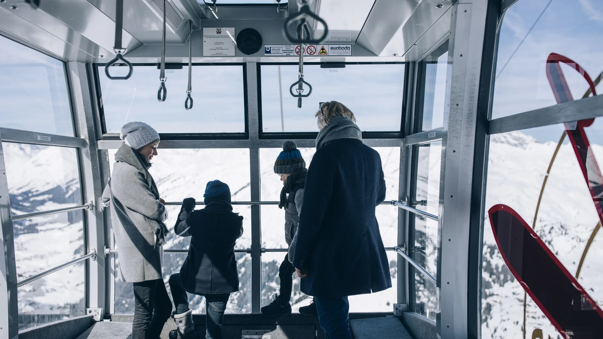 Picture gallery | Hotel Panorama in Lech am Arlberg Four people inside a cable car with a view of a snowy mountain landscape