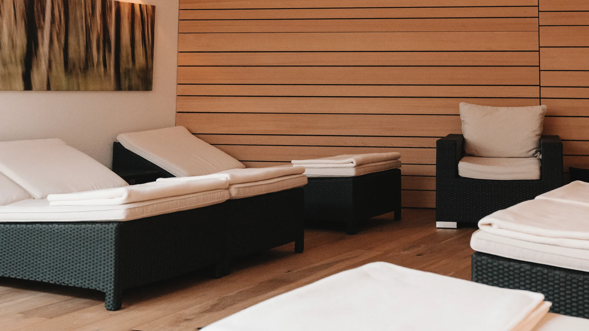Picture gallery | Hotel Panorama in Lech am Arlberg Relaxation room with cushioned loungers, white towels and a wooden slat wall