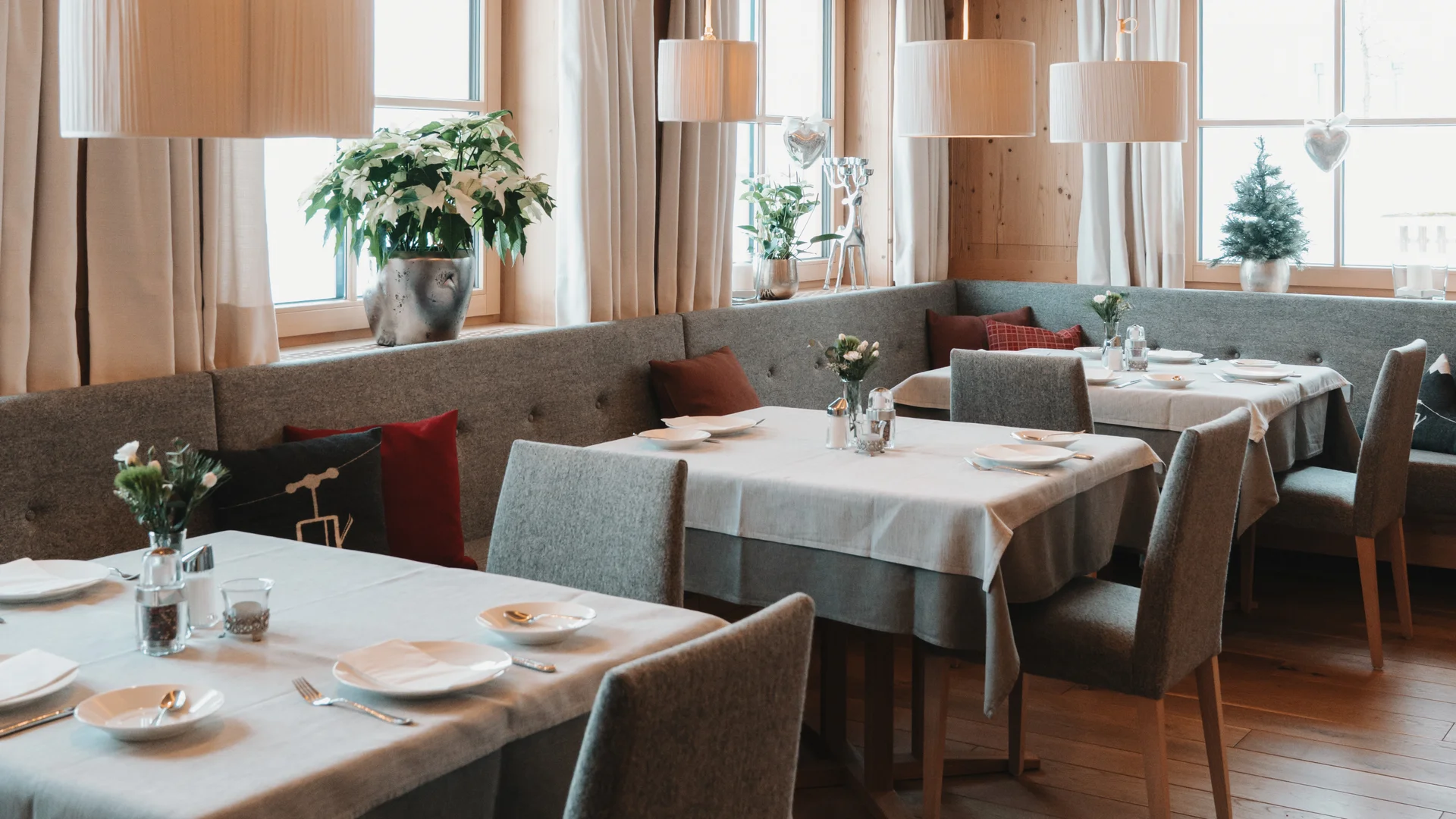 Cozy dining room with set tables, upholstered chairs and large windows