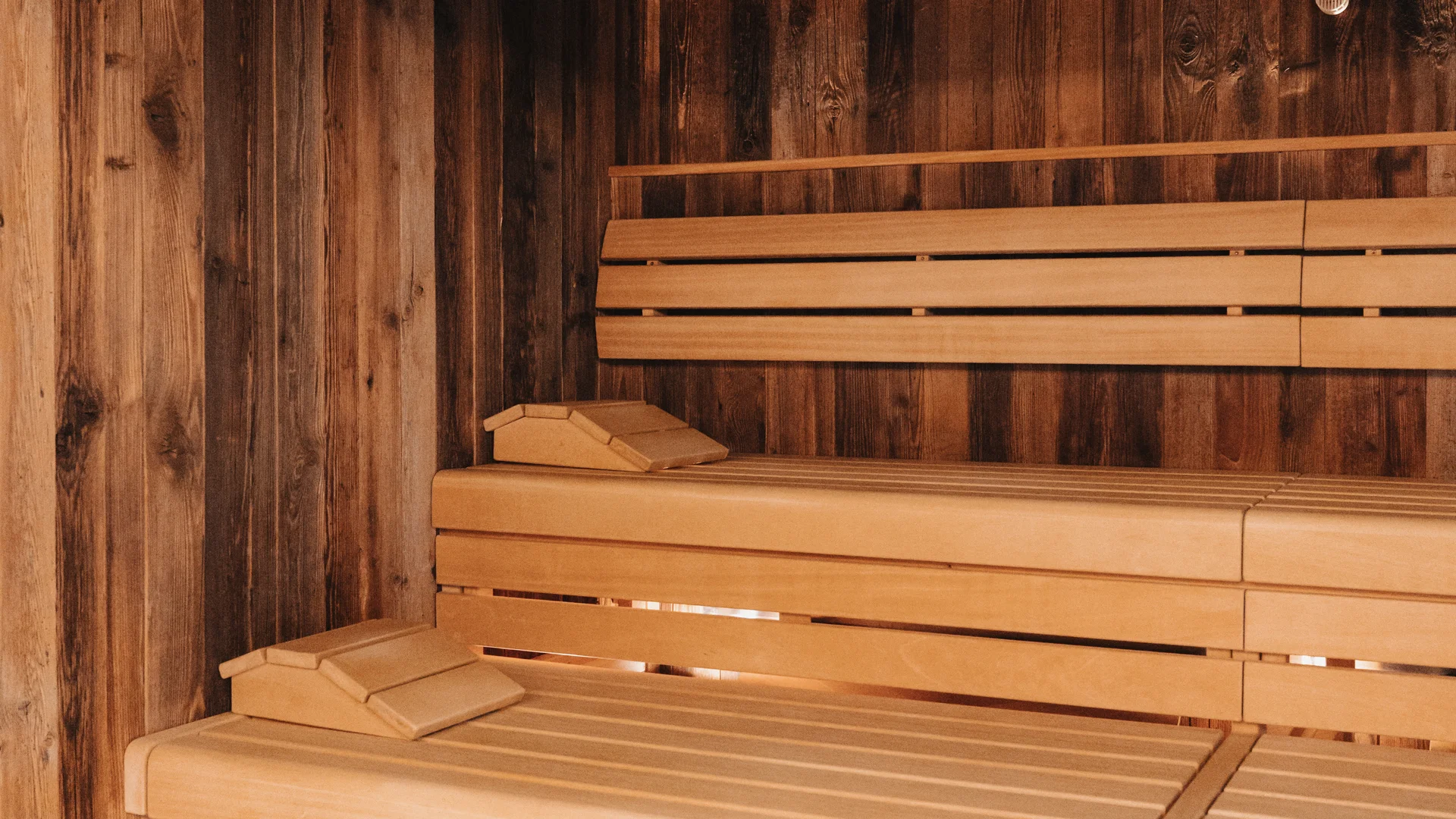 Picture gallery | Hotel Panorama in Lech am Arlberg Wooden sauna with tiered benches and a clock on the wall