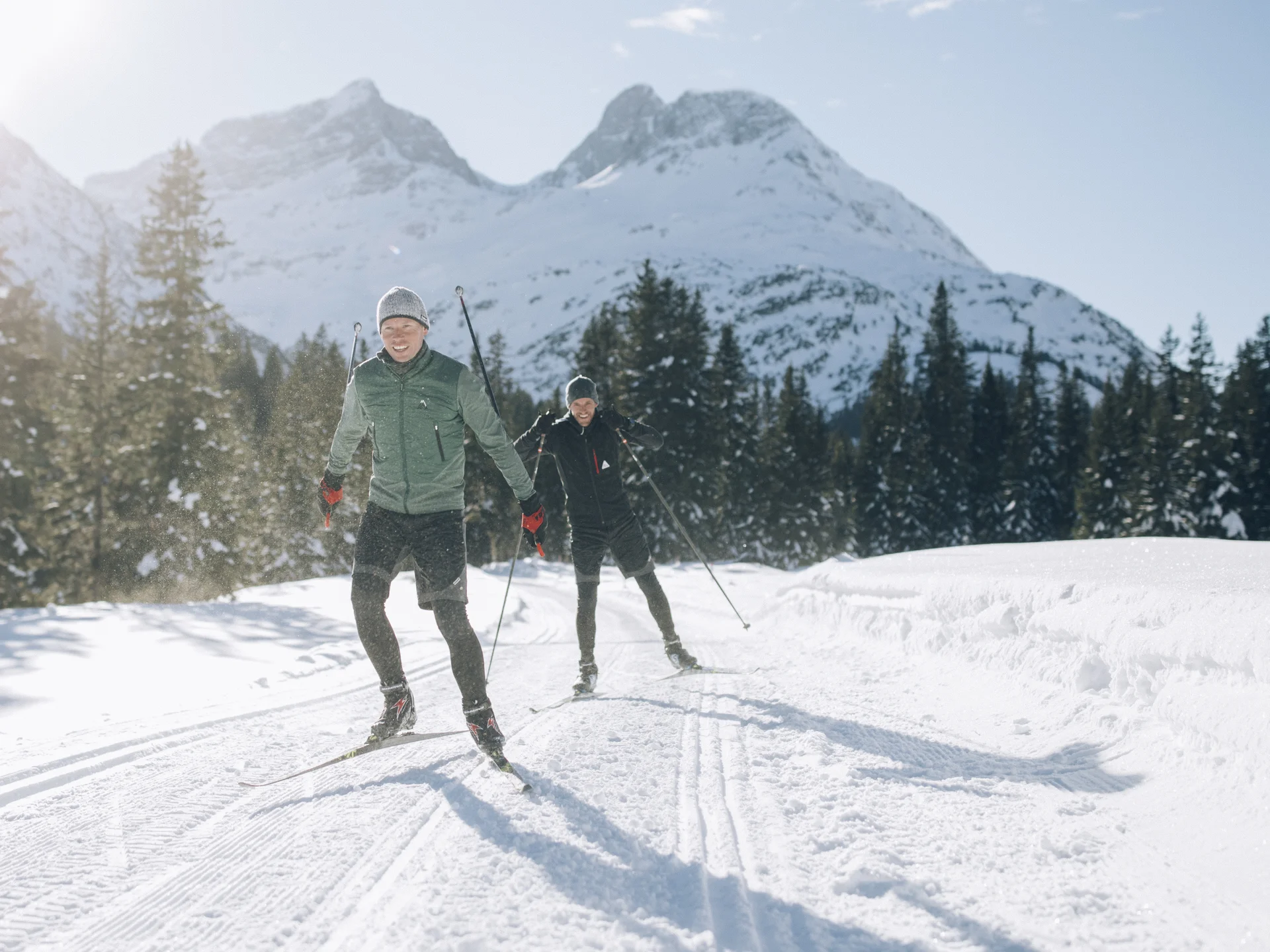 A ski holiday in Lech at Hotel Panorama Two cross-country skiers on a snowy trail with mountains in the background
