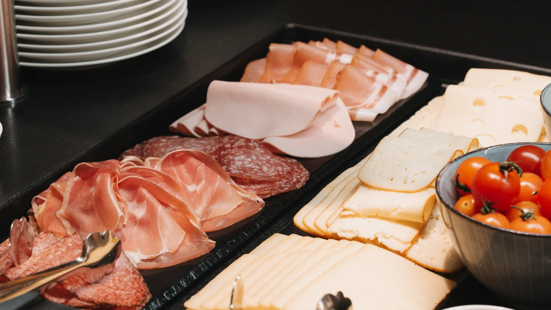 Picture gallery | Hotel Panorama in Lech am Arlberg Buffet with cold cuts, cheese, cherry tomatoes and stacks of plates