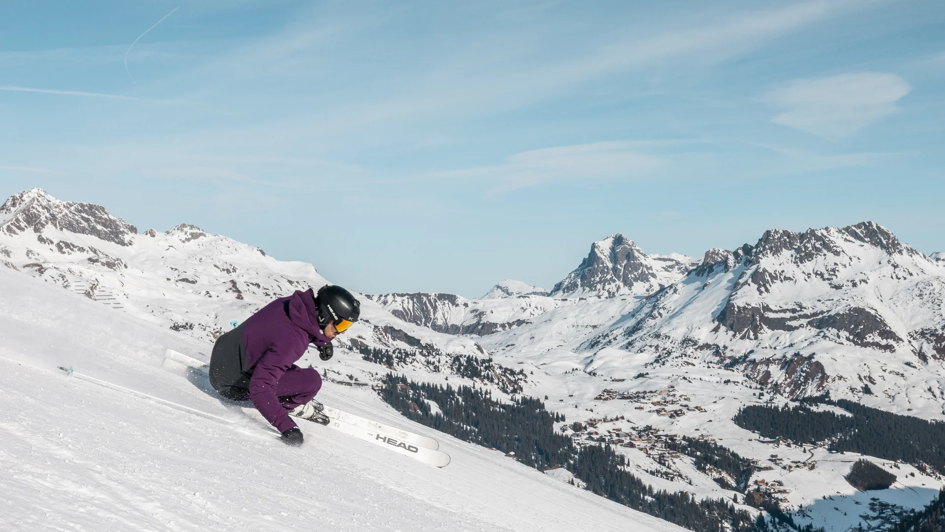 Picture gallery | Hotel Panorama in Lech am Arlberg Skier crouches low while descending a snowy slope against an alpine mountain backdrop