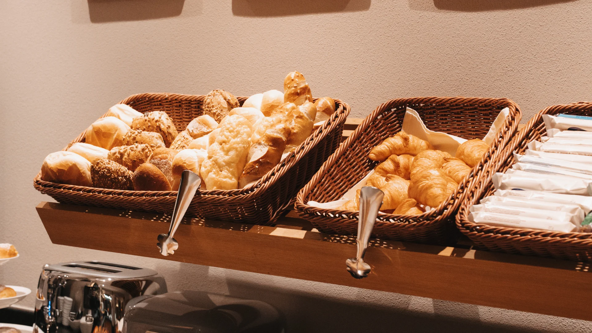 Picture gallery | Hotel Panorama in Lech am Arlberg Breakfast buffet with bread, rolls and croissants beneath wooden wall art