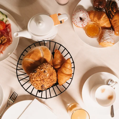 Inclusive services | Hotel Panorama in Lech am Arlberg Breakfast spread with bread, croissants, pastries, cold cuts, cheese, tea, coffee and juice