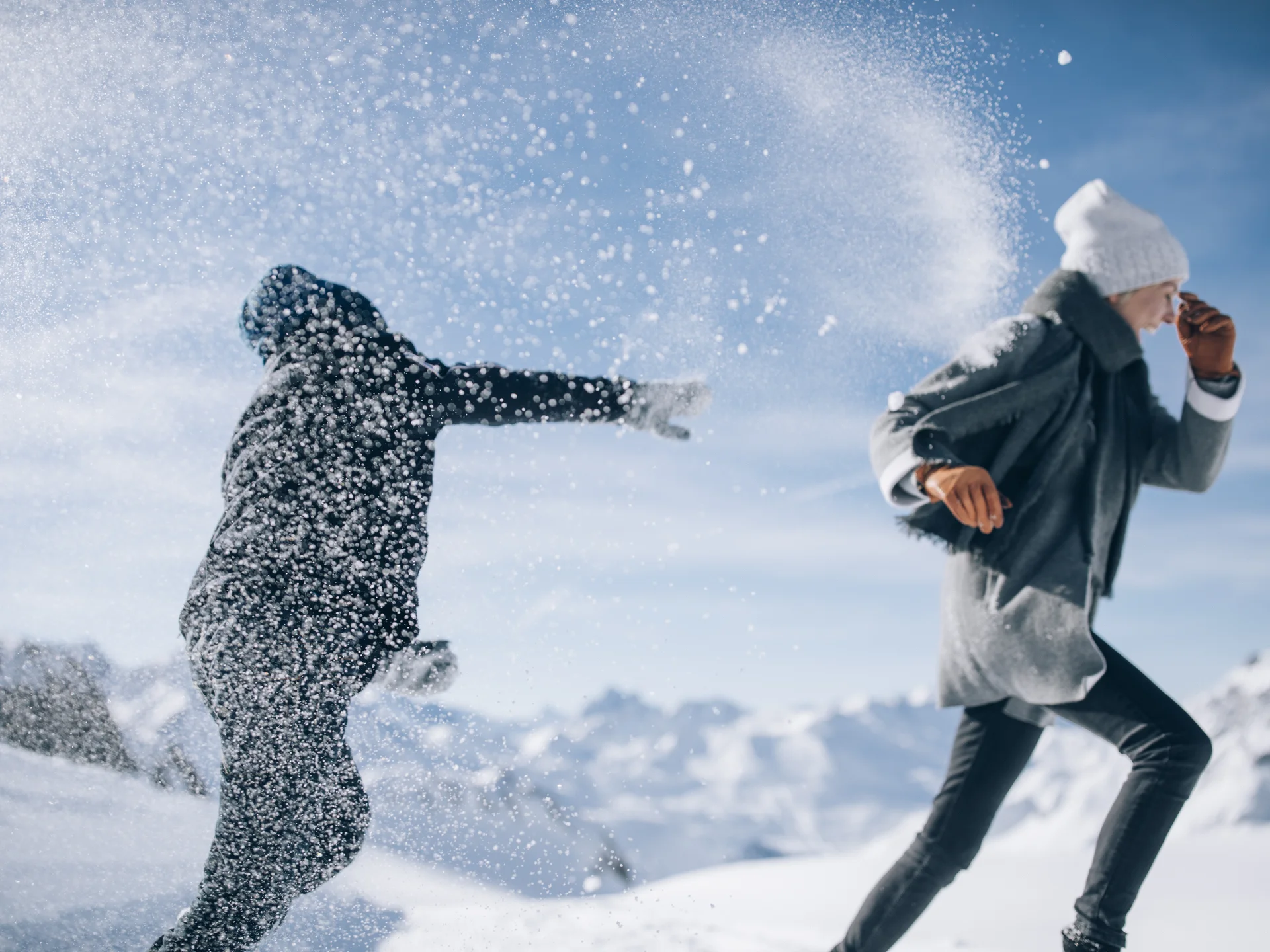 A ski holiday in Lech at Hotel Panorama Two people play in the snow as a cloud of snow swirls through the air
