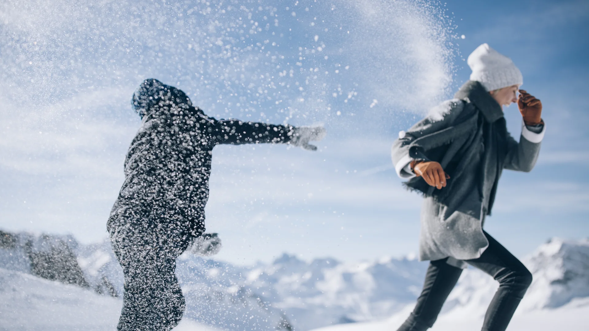 Picture gallery | Hotel Panorama in Lech am Arlberg Two people play in the snow as a cloud of snow swirls through the air