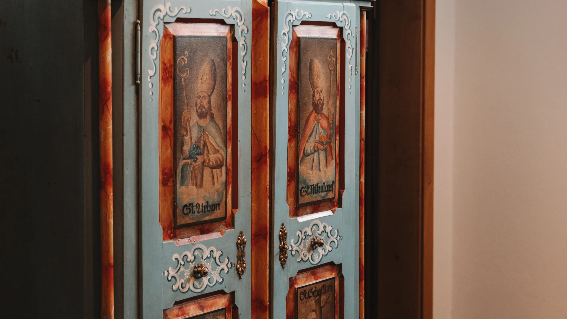 Picture gallery | Hotel Panorama in Lech am Arlberg Antique blue-painted cabinet with ornate details and four panels depicting figures
